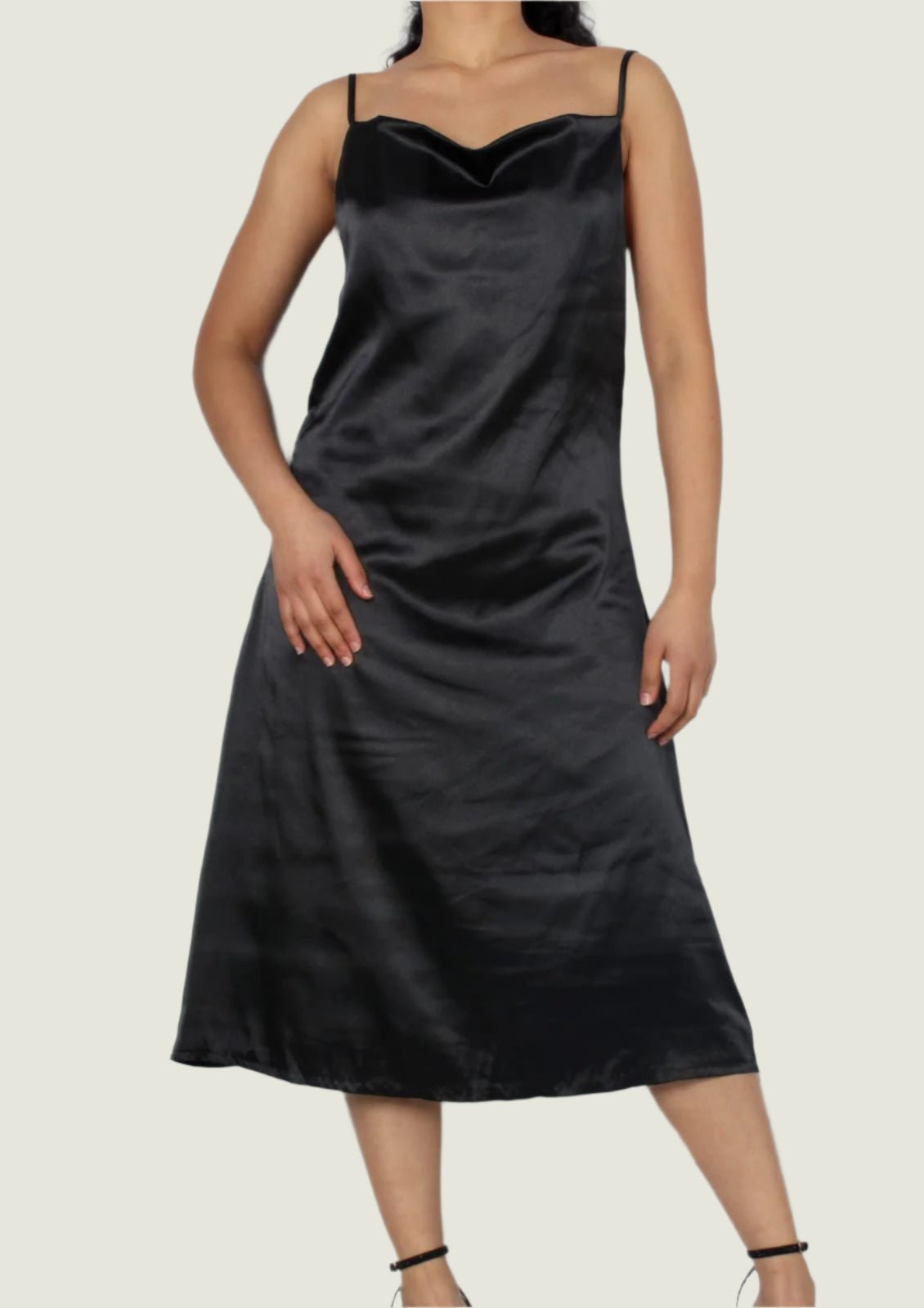 Black satin slip dress worn by a person on a white background
