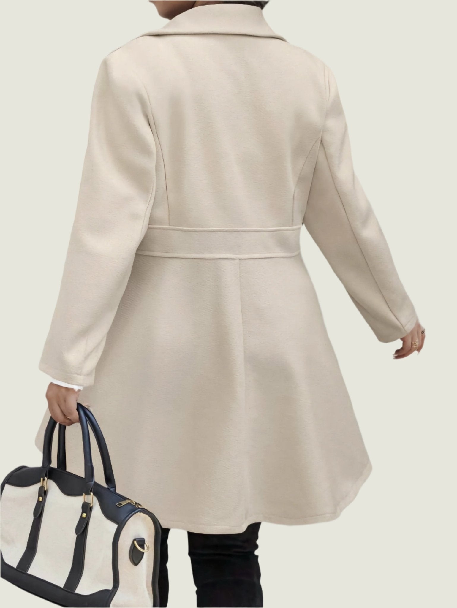 Person wearing a beige coat walking on a street.